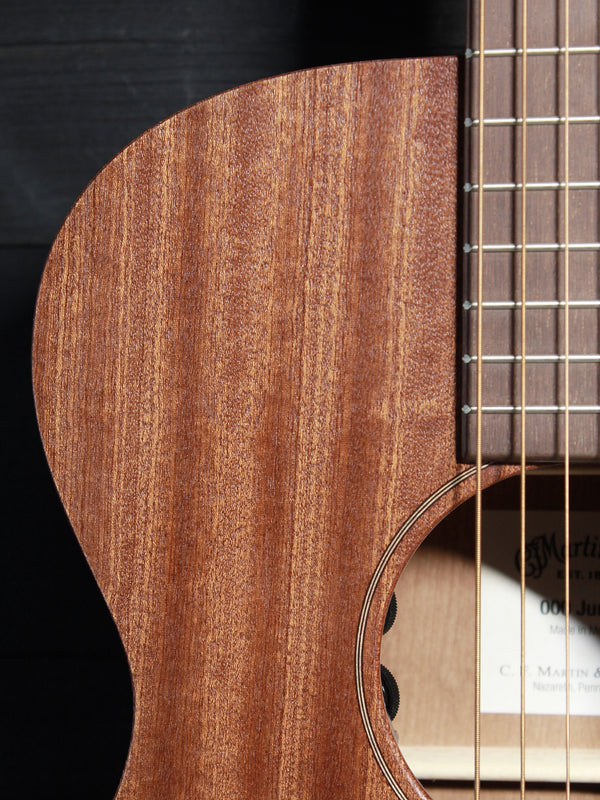 Close-up of the solid Sapele top on the Martin 000-Jr guitar showing upper bout and strings
