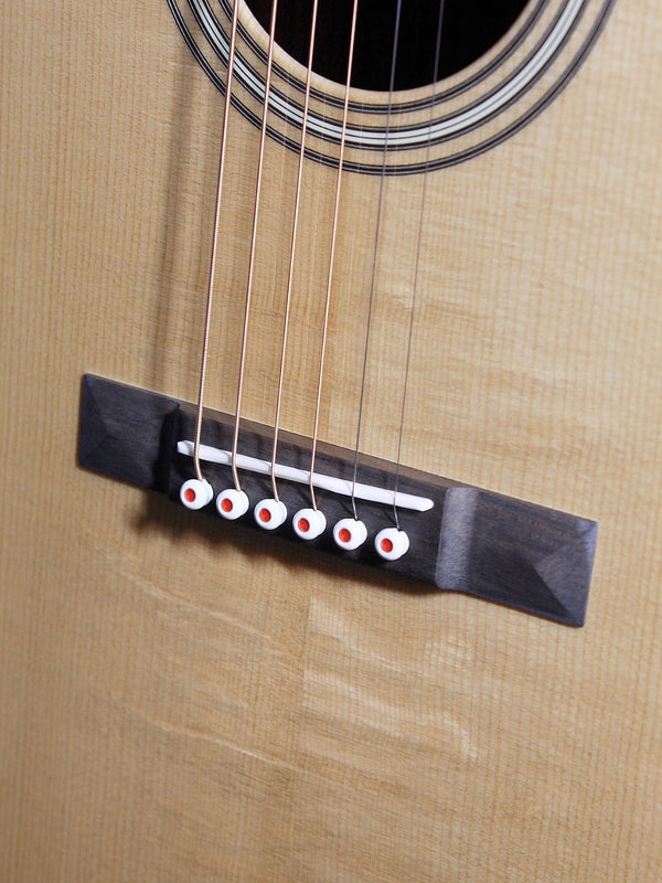 Martin 0012-28 Modern Deluxe 00 12-fret acoustic guitar showing bridge and saddle showing Bear claw spruce