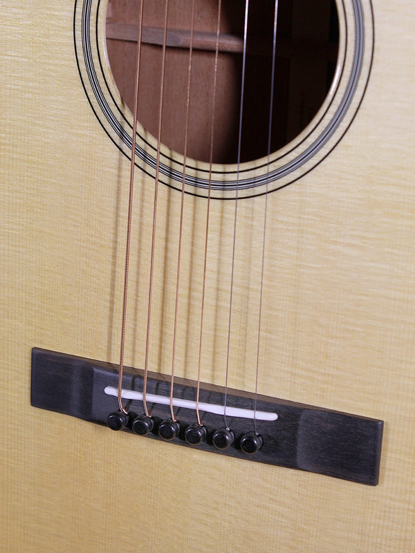 Bridge and saddle on top of Martin Custom Shop 00-12 Fret acoustic guitar designed by Chris Martin IV and Craig Thatcher