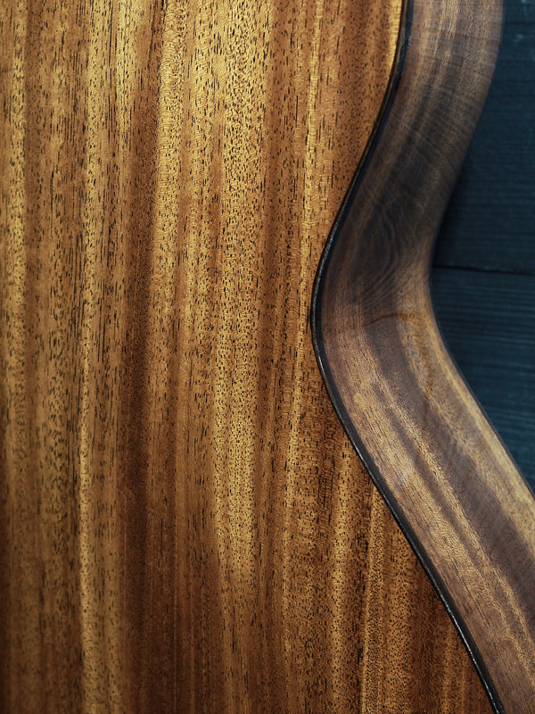 Back of Martin Custom Shop 0000/M guitar showcasing Sinker Mahogany wood grain mid section with sides
