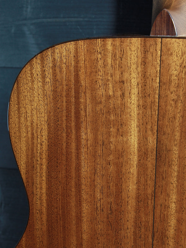 Back of Martin Custom Shop 0000/M guitar showcasing Sinker Mahogany wood grain upper bout close up