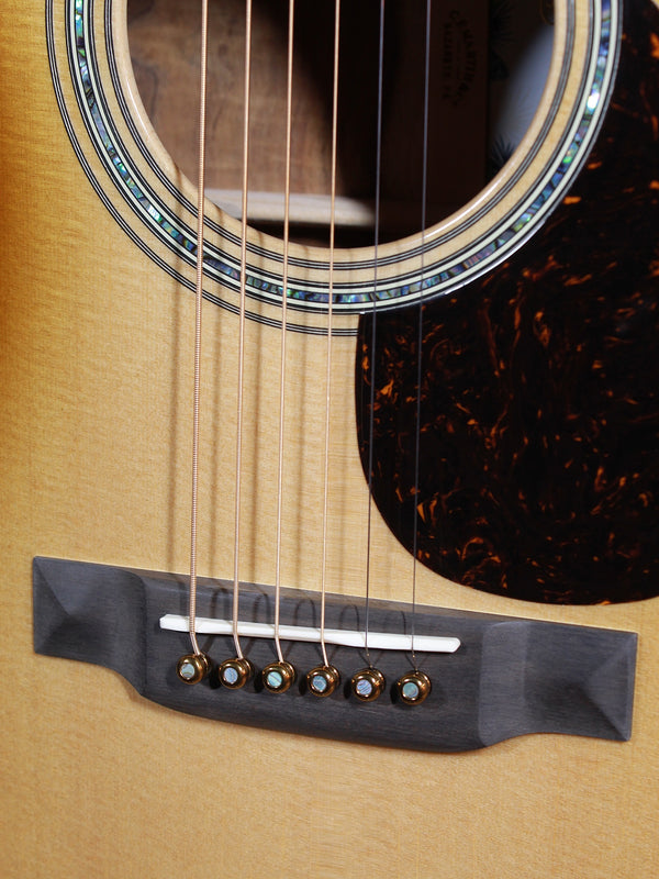 Martin O’ahu K-42 Hibiscus acoustic guitar front view showing bridge and Gold Liquid Metal bridge pins.