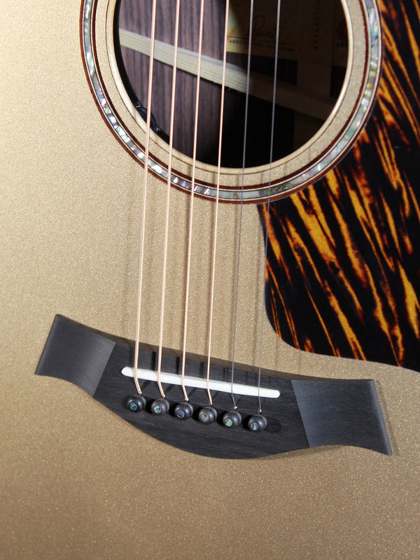 Taylor 814ce Limited Edition Casablanca Beige Metallic acoustic guitar showing bridge and saddle